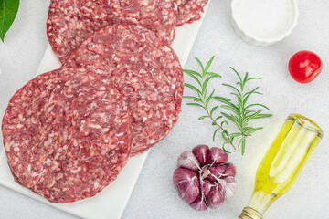 Raw burger patties. Fresh meat cutlets, spices, vegetables, herbs. Homemade American classic