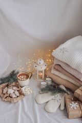 Cozy home interior with knitted sweaters, candles and Christmas decorations