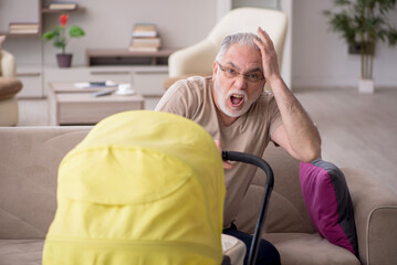 Old man looking after newborn at home