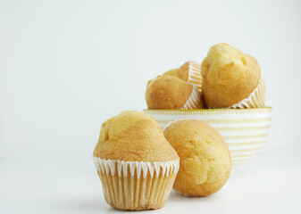 Close up. baked muffin on white background and porcelain bowl.