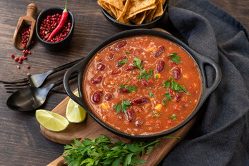 Mexican food chili con carne with corn chips nachos. Bean and corn soup, kidney bean stew