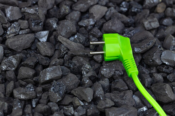 green plug lying on black coal, Environmental concept, renewable energy sources, co2 reduction,...