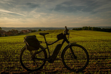Electric bicycle on green field with sunset colors near Ceske Budejovice city