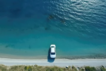 Tuinposter Topdown View Of Electric Car Driving By The Sea Aerial Photography Composition © Anastasiia