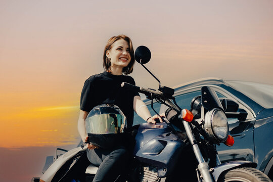 beautiful young female motorcyclist sits on a motorcycle.