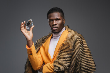 Dapper dark-skinned man adorned in a stunning yellow blazer and draped in a wild animal pelt,...