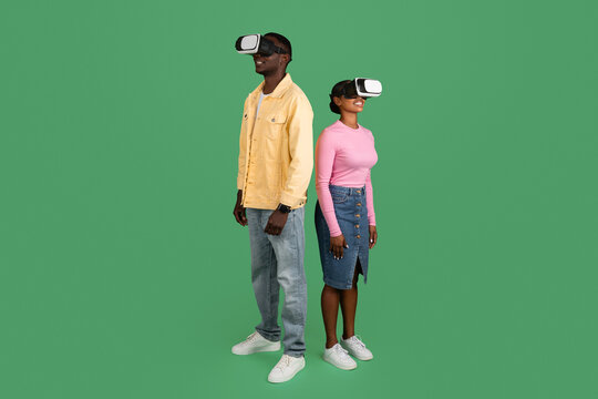 African american man and woman using VR glasses, green background