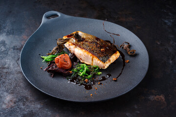 Traditional Japanese gourmet salmon fish steak tataki with algae, umeboshi fruit and wakame served...