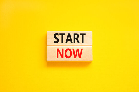 Start now symbol. Concept words Start now on beautiful wooden block. Beautiful yellow table yellow background. Business marketing, motivational start now concept. Copy space.