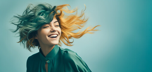 A young, smiling, and confident girl with ombre turquoise and orange hair, which the wind is blowing in various directions.