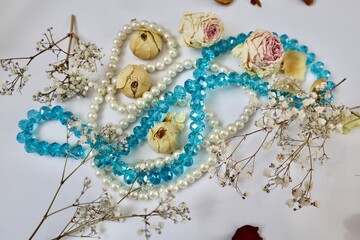 White and blue beads with dried rose buds