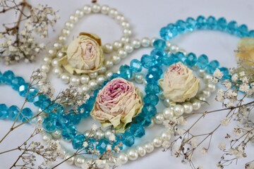 White and blue beads with dried rose buds