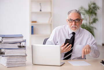 Fototapeta premium Old male employee and too much work in the office