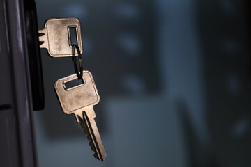 Set of keys placed in a lock with an out of focus background