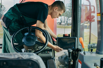 Young engineer installing autopilot system on tractor