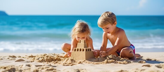 two small children playing in the sand on the beach - obrazy, fototapety, plakaty