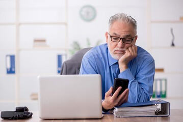 Old male employee working in the office