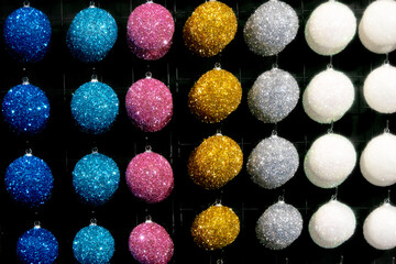 Multi-colored New Year's balls hang neatly in a row.