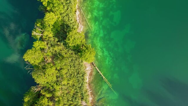 Purest mirror water of mountain lake and green forest landscape in summer to early autumn sunny morning.