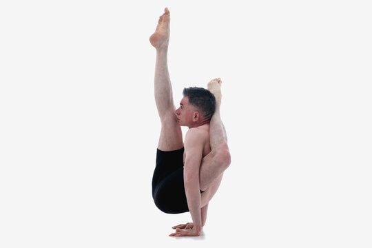 Eka pada sirsasana (shirshasana), Ashtanga yoga  Side view of man wearing sportswear doing Yoga exercise against white background. Horizontal image.