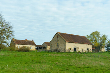 Old abandoned farm with various brick buildings in spring.