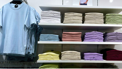Sale of summer colored T-shirts in the store of the shopping center. A collection of seasonal...