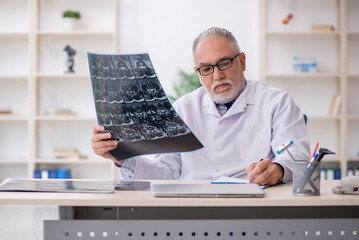 Old male doctor radiologist working in the clinic