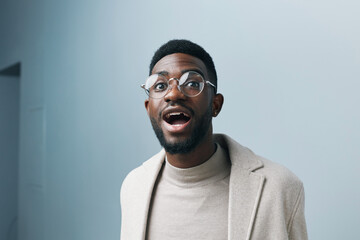Cheerful african man wearing glasses jean jacket having white snow smile pointing fingers aside at copy space for your text advertisement, advertise teeth whitening or eyewear store good offer concept