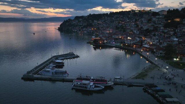 Aerial Twilight drone view of Ohrid City at Night in North Macedonia. Old Town on Ohrid lake with a beautiful fortress