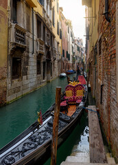 Fototapeta na wymiar Narrow canal with gondola in Venice, Italy. Architecture and landmark of Venice. Cozy cityscape of Venice.