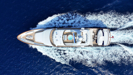 Aerial drone photo of latest technology mega yacht with wooden deck cruising deep blue...