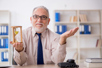 Old male employee in time management concept