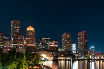 Obraz premium Panoramic city view of Boston Harbour and Seaport Blvd evening and night time, Massachusetts. An intellectual, technological and political center.