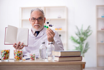 Old male doctor holding molecular model