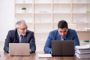 Two male employees working in the office