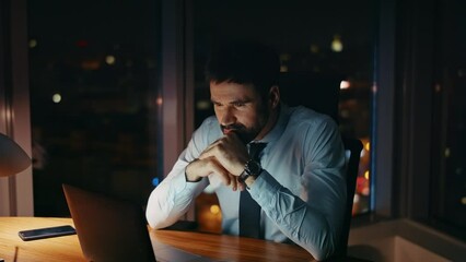 Worried manager sitting night workplace looking laptop close up. Worker tired 
