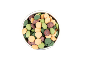Bowl of forest green brown tan camoflage colored candy coated chocolate pieces top down