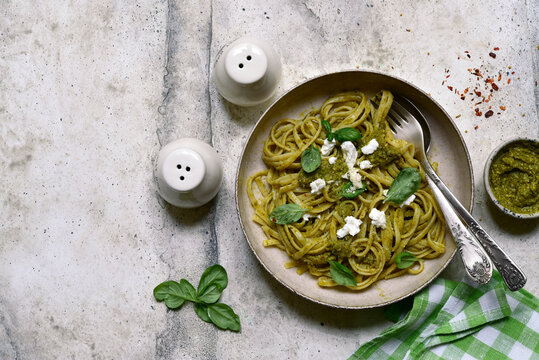 Pasta with pesto sauce, traditional dish of italian cuisine. Top view with copy space.