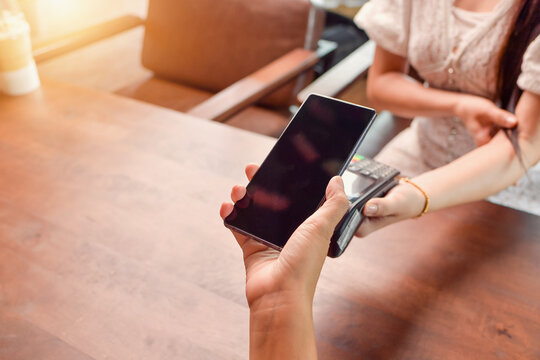 Man making a contactless payment on a credit card reader with a mobile phone