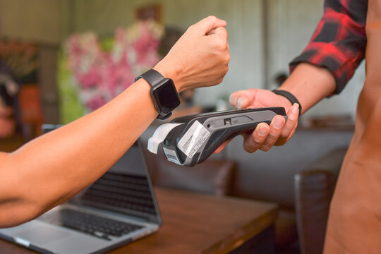Woman making a contactless payment on a credit card reader with a smart watch