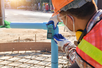 Construction worker using a  Laser measuring tool on a construction site, Thailand