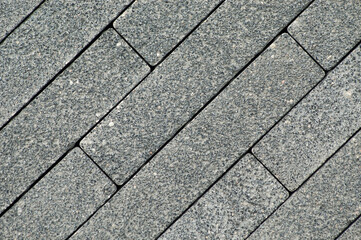gray decorative paving slabs made of rectangular blocks laid out diagonally close-up