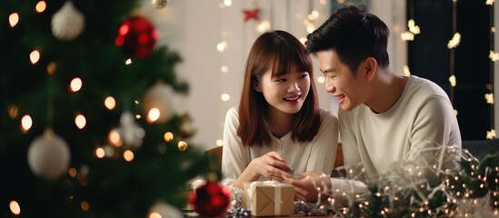 Happy and cheerful Asian romantic lovers celebrating christmas at home