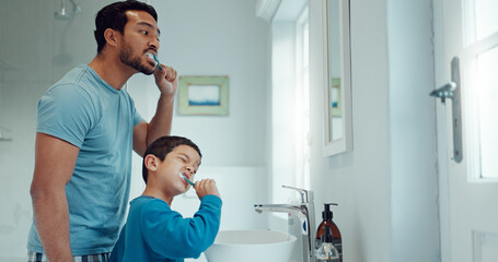 Father, child and brushing teeth in family home bathroom while learning or teaching dental hygiene....