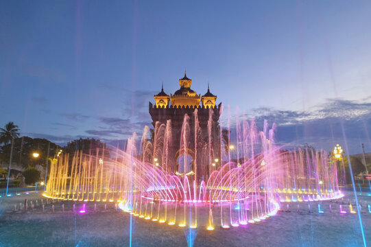 Illuminated water fountain in front of Patuxai (Patuxay) at dusk, Vientiane, Laos
