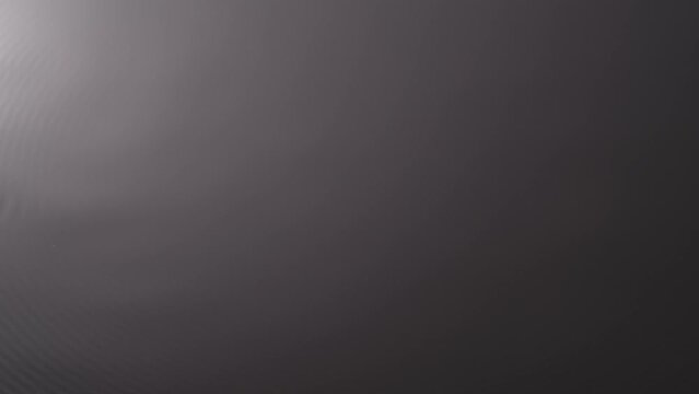 Water surface monochrome light, creating circles and ripples under ultra sound vibrations, abstract background template