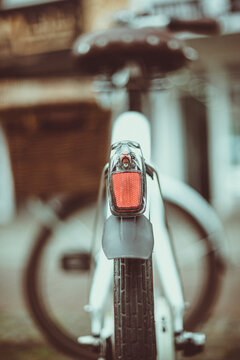 Close-up rear view of a white bicycle parked in the street