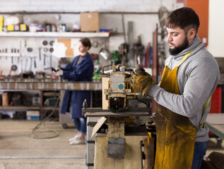 Portrait of man working with drilling machine on metal plate. High quality photo