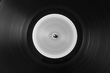 Detalle de los microsurcos de un antiguo disco de vinilo en movimiento, en  blanco y negro