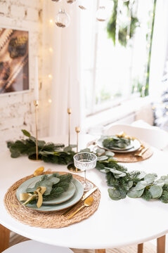 Decoration of the table in New Year's or Christmas style. Christmas tree branches and exquisite candles.